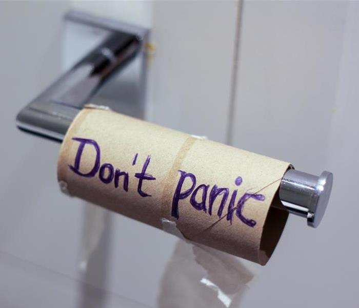 An empty toilet paper roll with "Don't Panic" written on it.