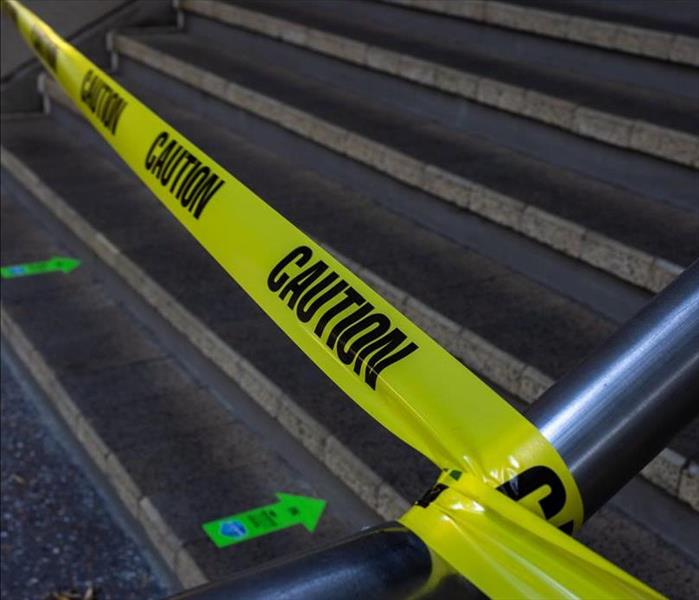 Caution tape hangs over a concrete stairway
