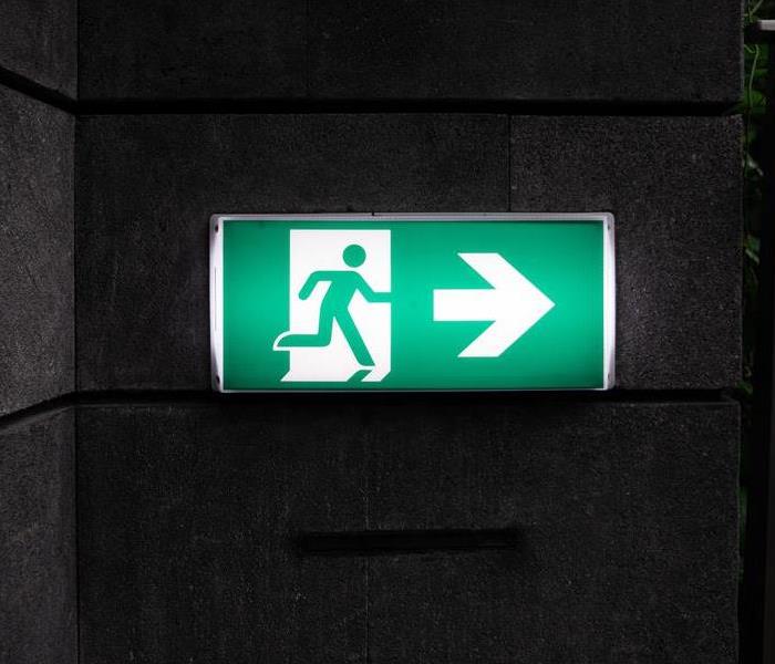 A green exit sign in a dark room