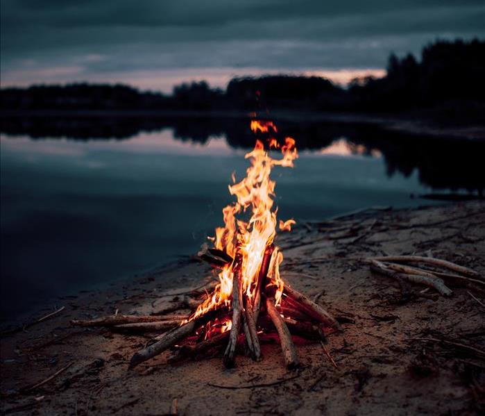 A small bonfire on a beach at dusk.